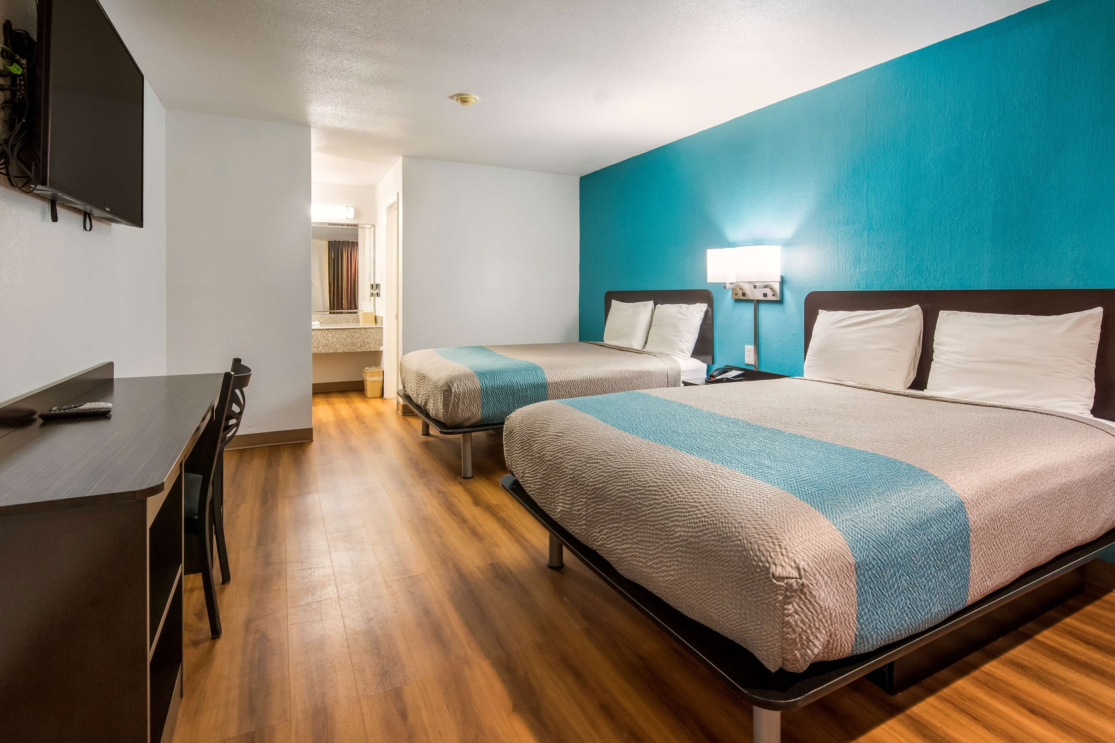 Una habitación de hotel con dos camas, un escritorio y un televisor.
