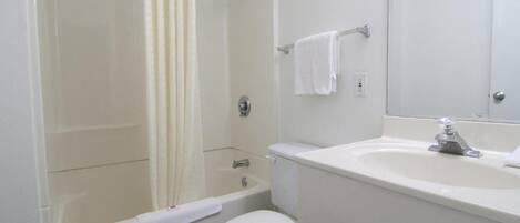 A bathroom with a bathtub, toilet, and sink.