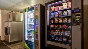Dos máquinas expendedoras en un pasillo, una con bebidas y la otra con aperitivos.