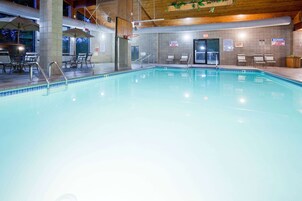 Una piscina techada, sillones reclinables de piscina