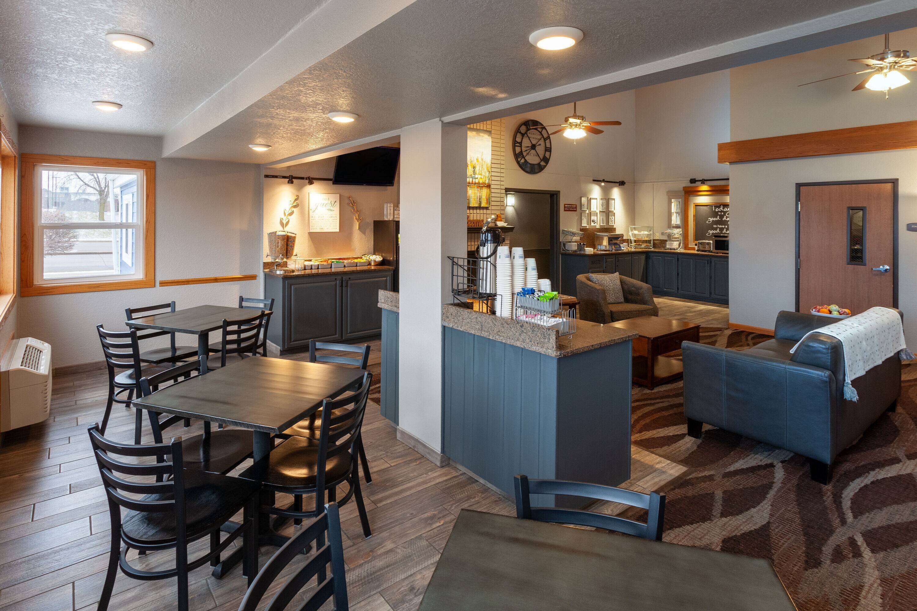 A spacious kitchen with a dining area, a living room with a sofa and a coffee table, and a kitchen counter with various appliances.