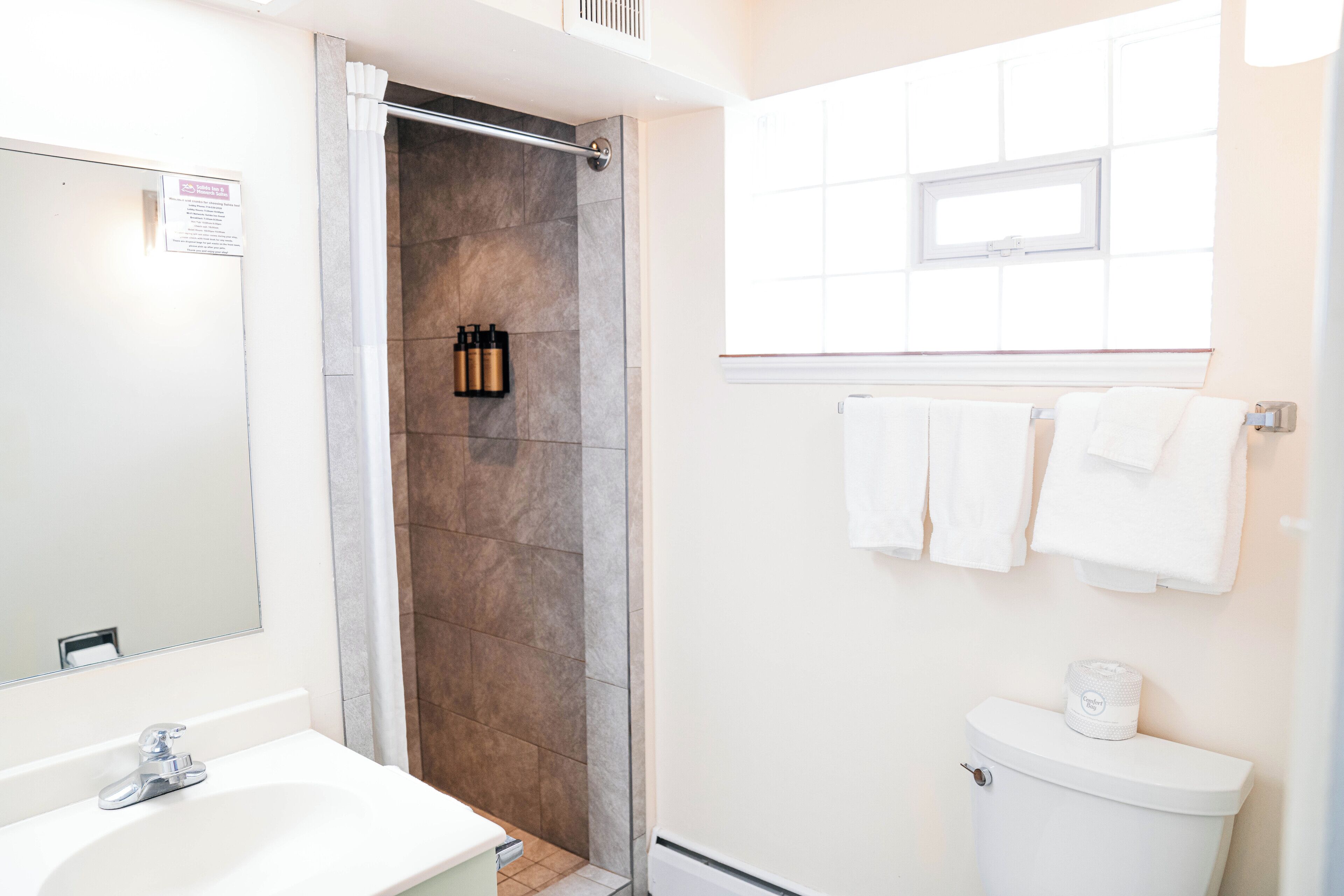 Ein Badezimmer mit Dusche, Toilette und Waschbecken.