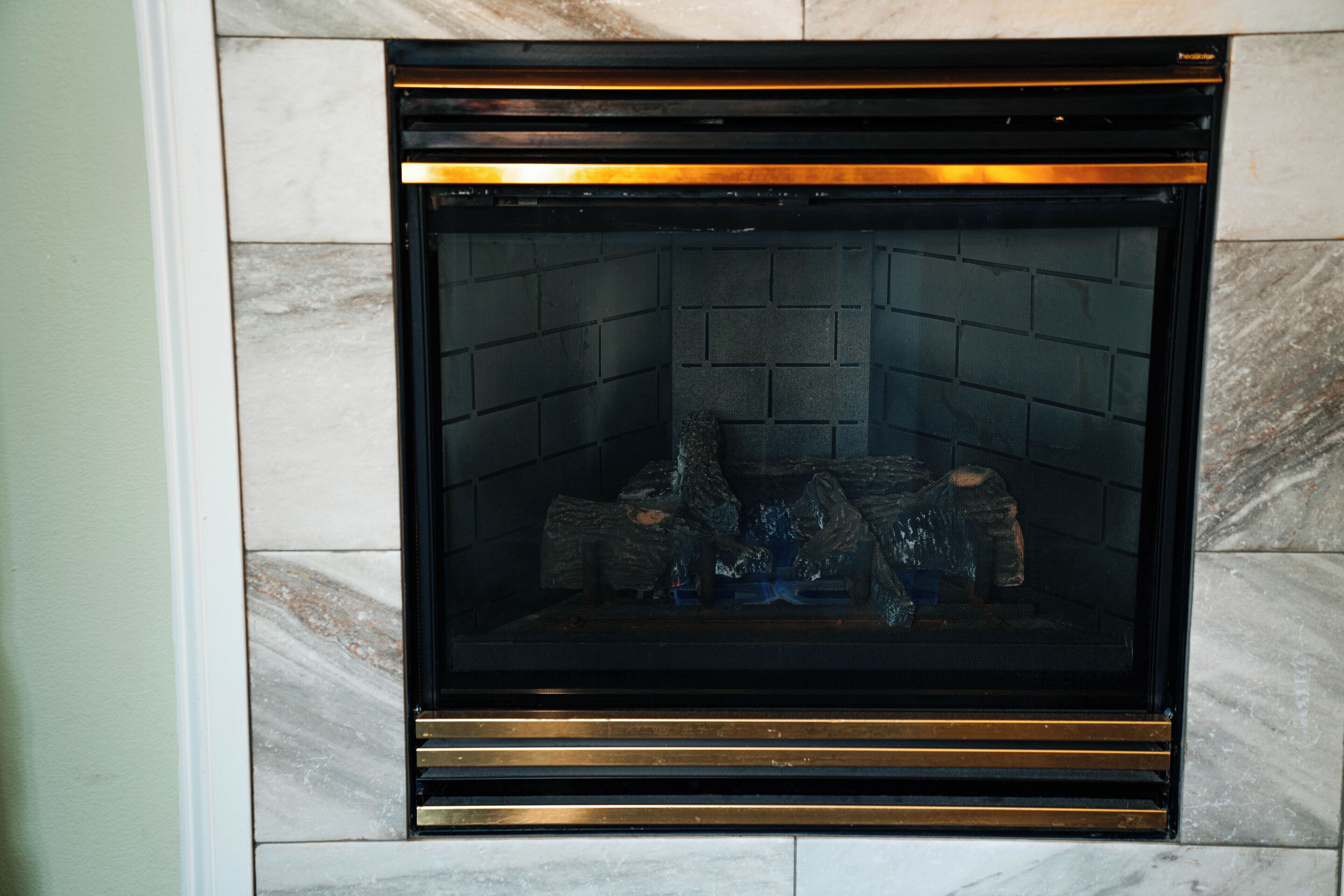 A fireplace with a black frame and a marble surround.