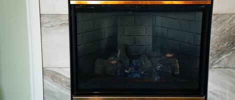 A fireplace with a black frame and a marble surround.