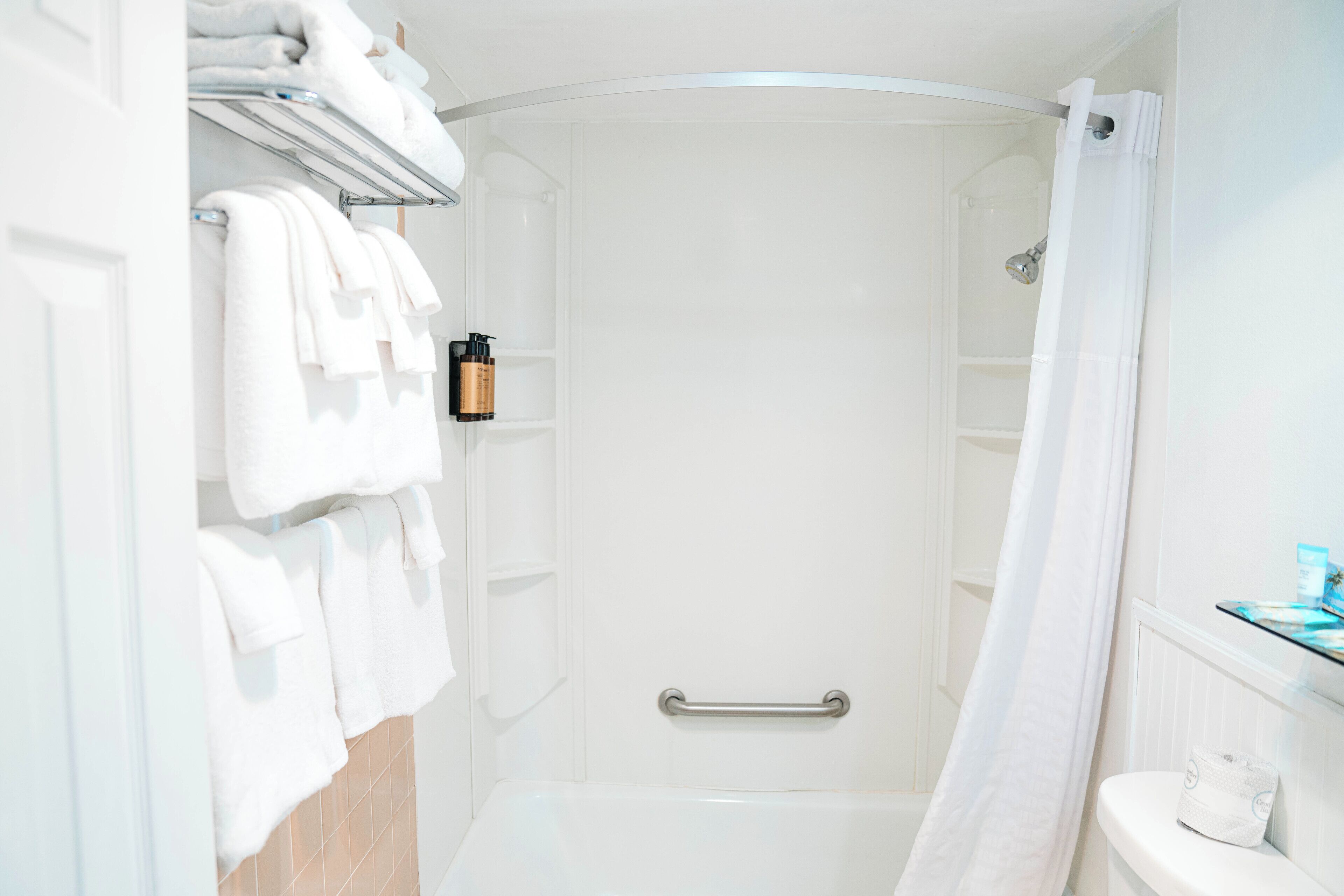 A modern bathroom with a walk-in shower, a toilet, and a towel rack.