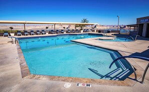 Zona de piscina con sillones reclinables, bar en la piscina y vistas despejadas del paisaje circundante.