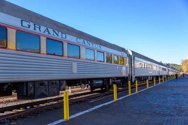 A train with "GRAND CANYON" written on its side at a station platform. - Super 8 by Wyndham Williams West Route 66/Grand Canyon Area (Williams)