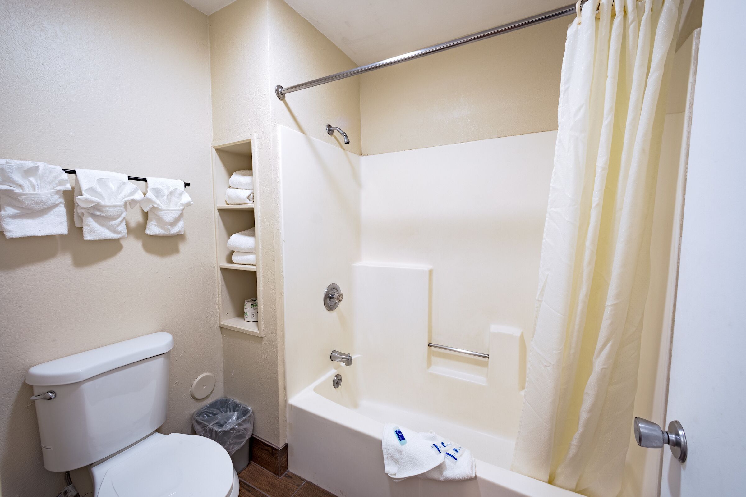 A bathroom with a toilet, bathtub, and shower curtain.