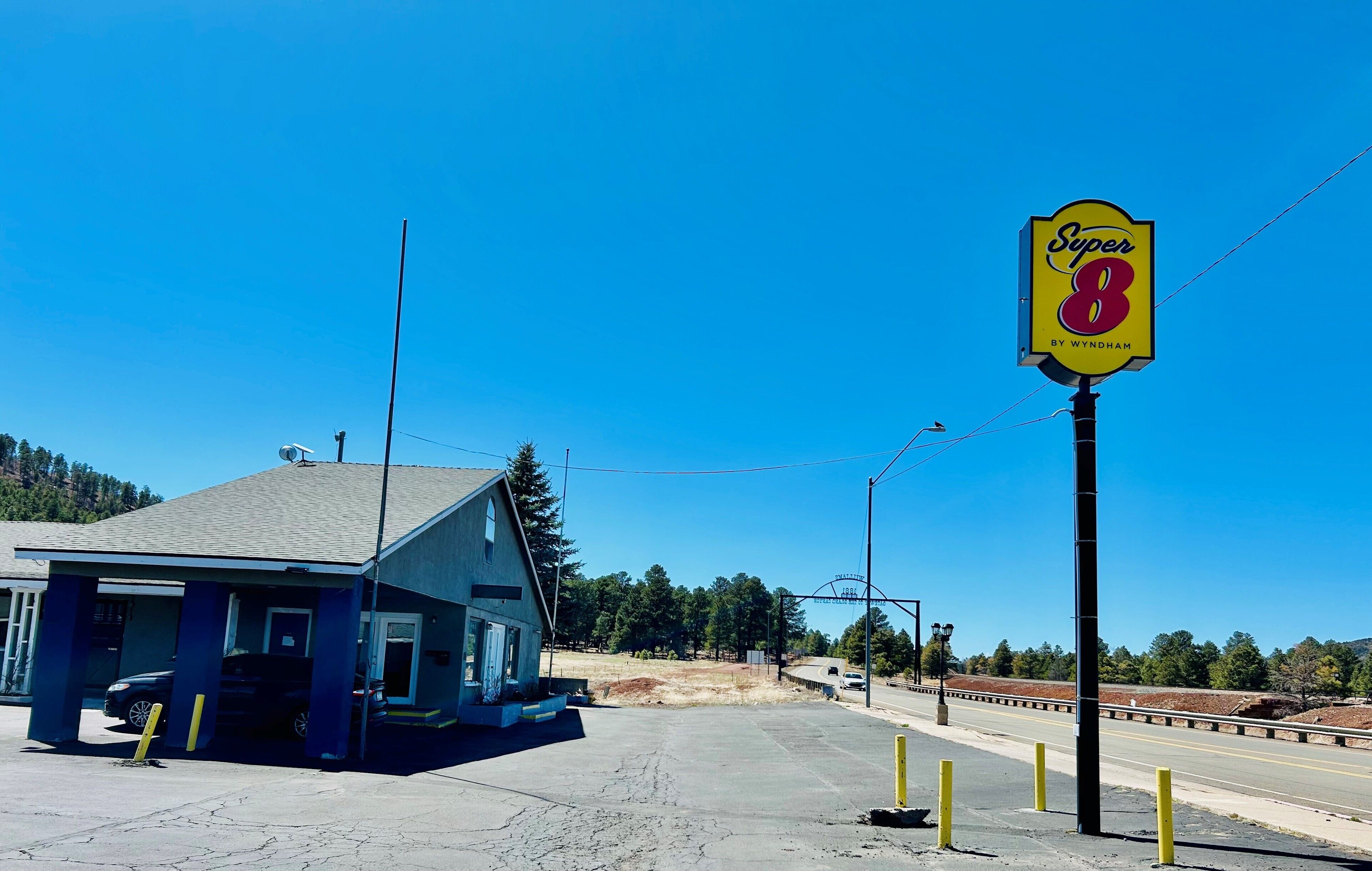 A small building with a blue exterior and a sign reading "Super 8 by Wyndham" in the foreground.