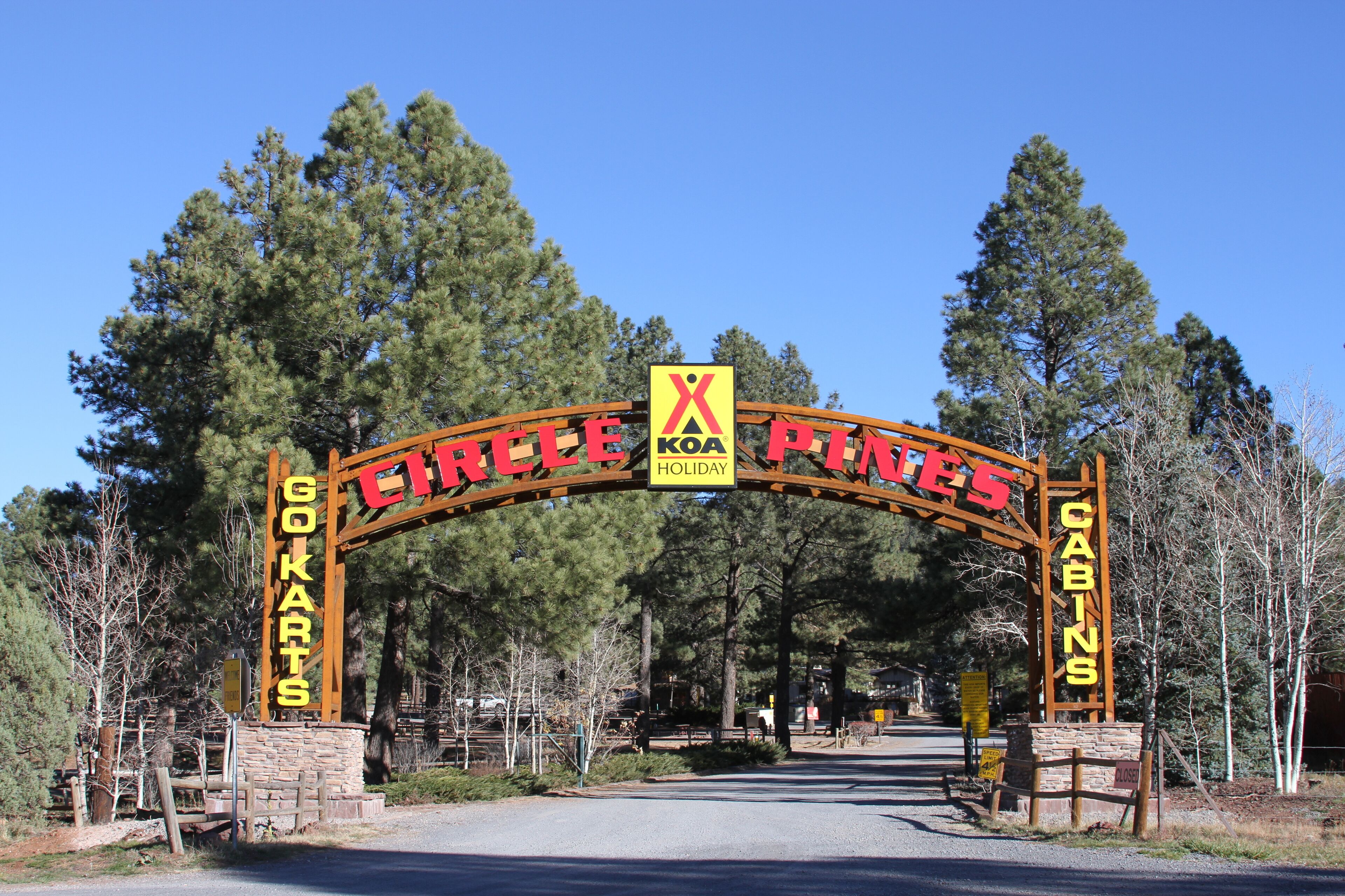 An archway with the text "CIRCLE OF CABINS" and "X KONA HOLIDAY" indicating a holiday destination.