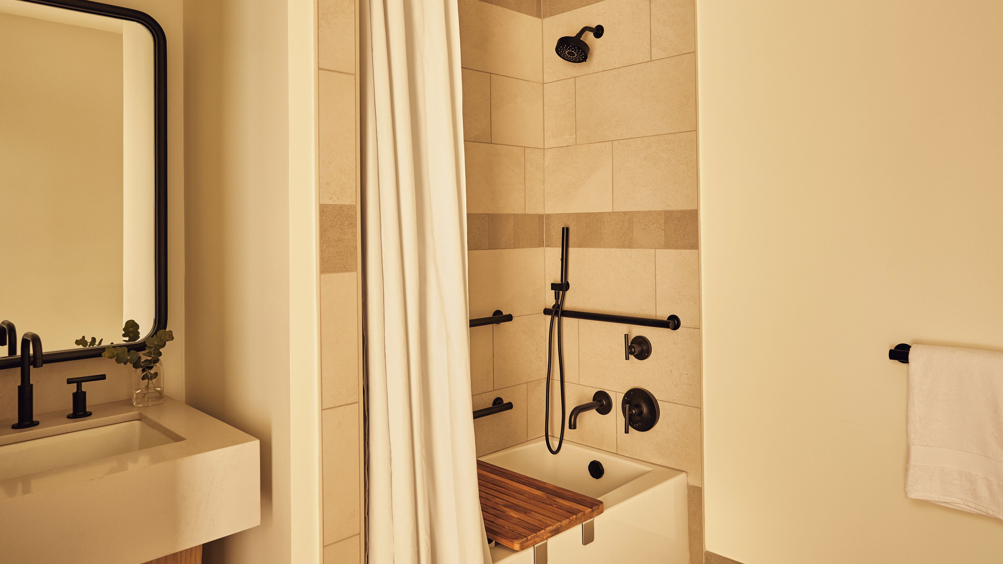 A bathroom with a shower, a sink, and a mirror.