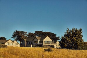 A large house with a balcony, surrounded by tall trees and a field. - Hill House at Trailborn Mendocino, Outdoor Collection by Marriott Bonvoy (Mendocino)