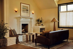 A cozy living room with a fireplace, a sofa, a coffee table, and a potted plant. - Hill House at Trailborn Mendocino, Outdoor Collection by Marriott Bonvoy (Mendocino)