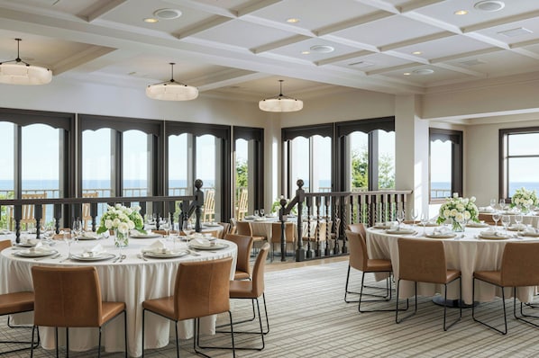 A restaurant with round tables set for dining, large windows with a view, and a ceiling with recessed lighting. - Hill House at Trailborn Mendocino, Outdoor Collection by Marriott Bonvoy (Mendocino)
