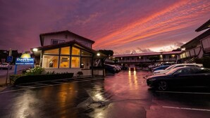 A Days Inn with a parking lot and a building with a glass facade. - Days Inn by Wyndham Monterey Downtown (Monterey)