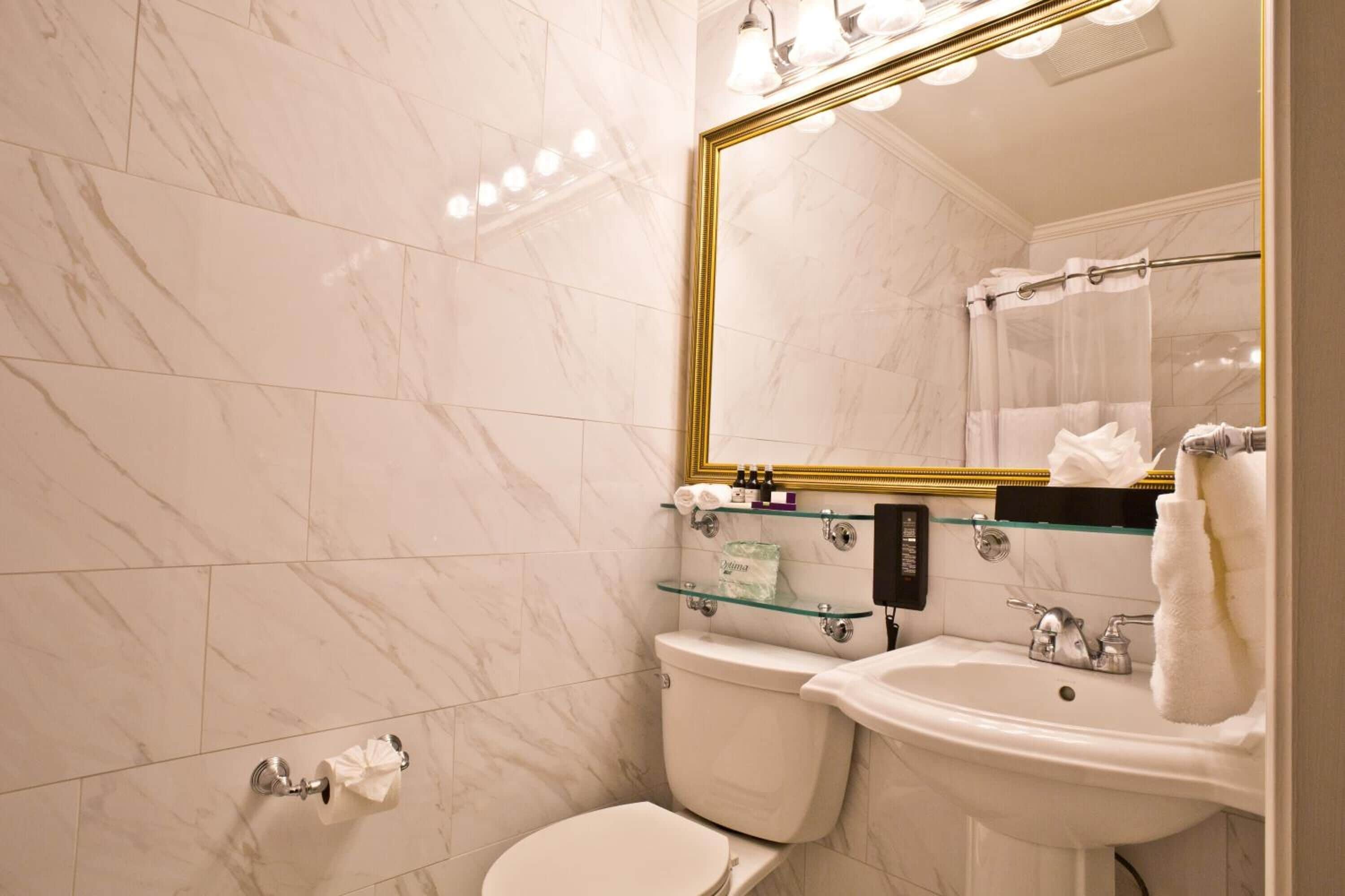 Un baño con inodoro, lavamanos y espejo.