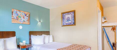 Habitación de hotel con dos camas, cabecero de madera, mapa mural y un cuadro enmarcado.