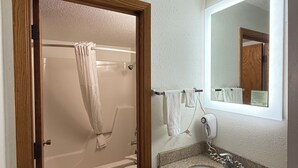A bathroom with a shower, toilet, and sink. - Super 8 by Wyndham West Fargo Main Ave ND (West Fargo)