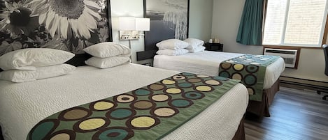 A hotel room with two beds, a large wall mural, a window with curtains, and a wall-mounted air conditioning unit.