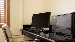 Un'area di lavoro con un portatile, un computer desktop e una sedia.