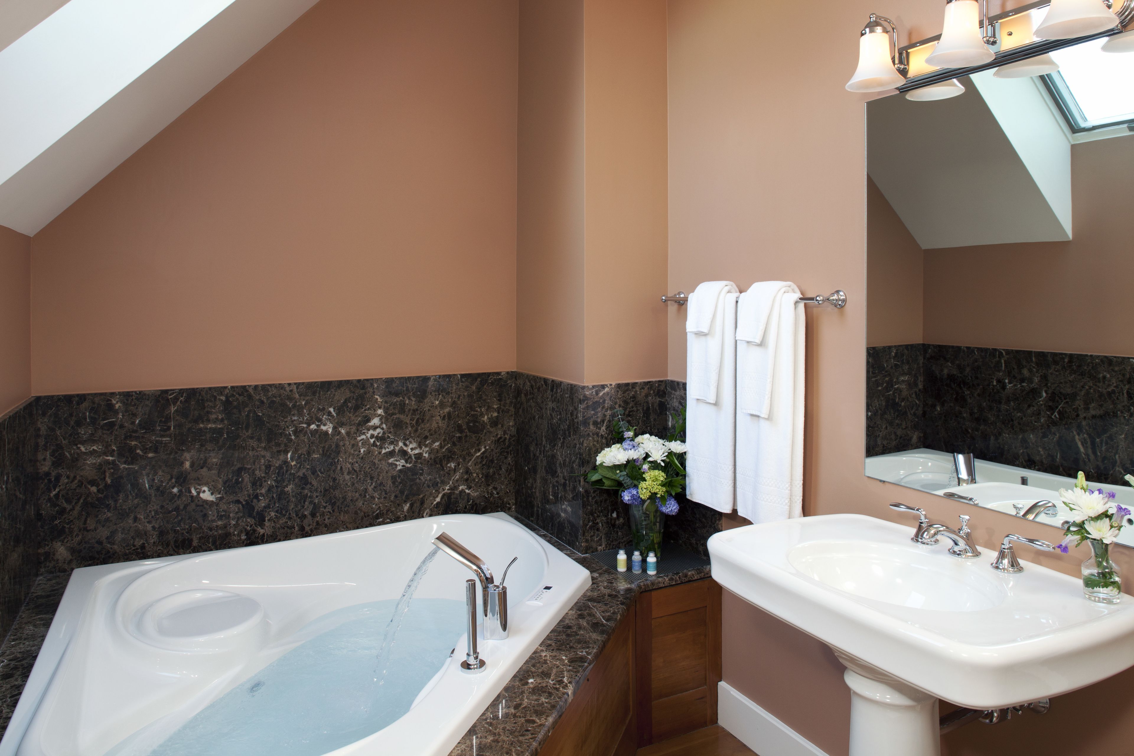 A bathroom with a bathtub, a sink, and a mirror.
