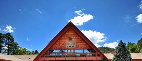 A lodge with a prominent triangular roof, a sign reading "Kohler's Ranch Lodge," and a large entrance with a covered porch.