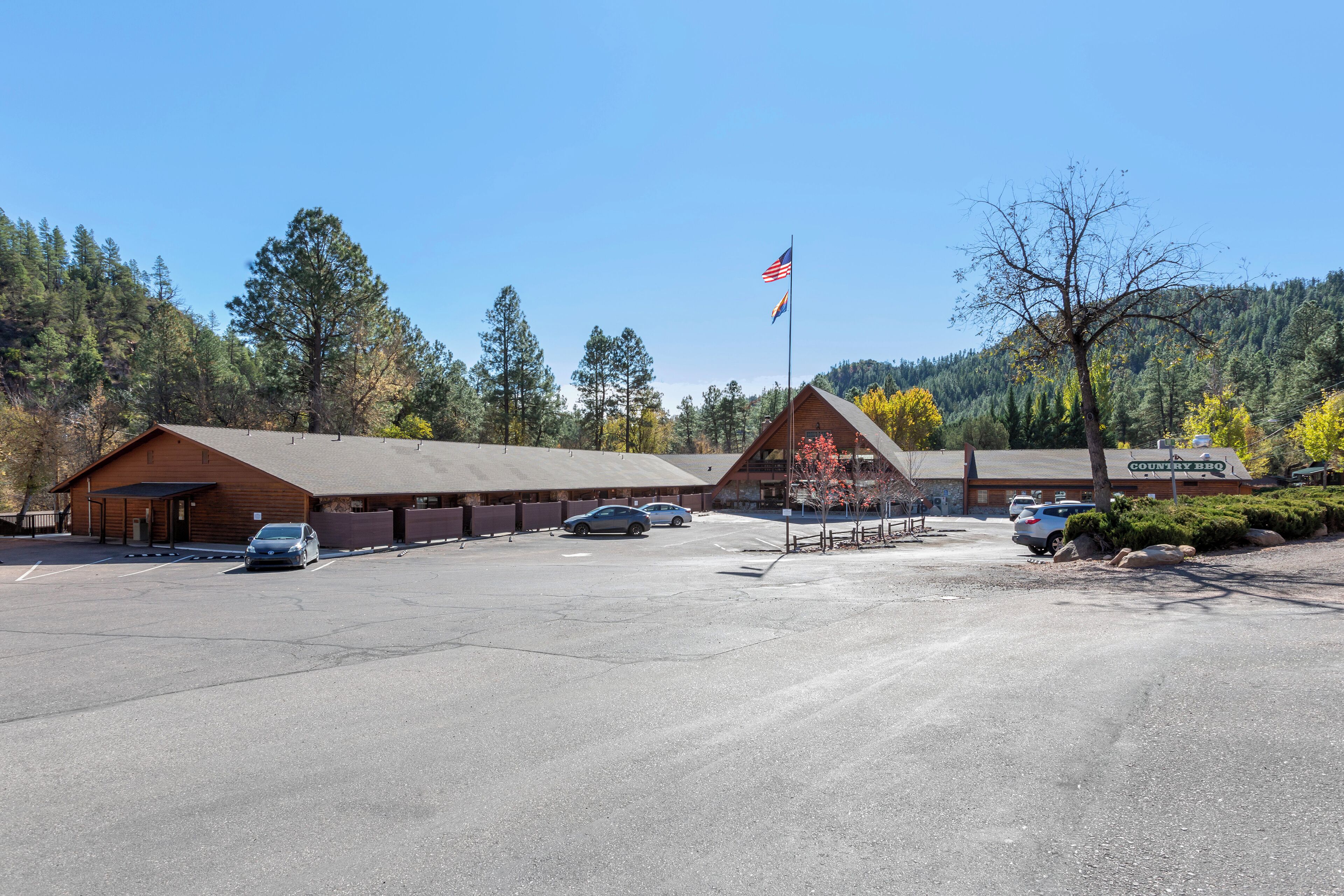 A building with a large parking lot and a flagpole with an American flag.