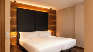 A double bed in a modern room with wooden paneling and two pendant lights. - Gran Derby Suites Hotel, a Small Luxury Hotels of the World (Barcelona)