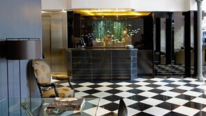 A lobby with a checkered floor, a reception desk, and a modern chandelier. - Gran Derby Suites Hotel, a Small Luxury Hotels of the World (Barcelona)