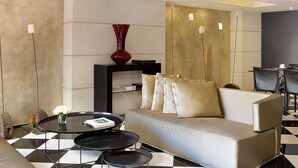 A modern living room with a sofa, a coffee table, and a red vase. - Gran Derby Suites Hotel, a Small Luxury Hotels of the World (Barcelona)
