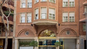 A multi-story brick building with a central entrance, large windows, and a balcony on the left side. - Gran Derby Suites Hotel, a Small Luxury Hotels of the World (Barcelona)