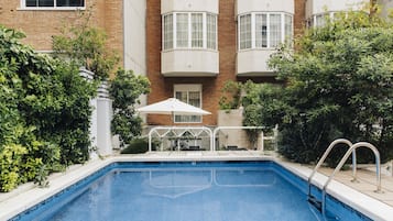 Una piscina al aire libre, tumbonas