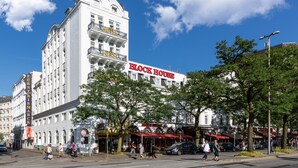 Un edificio histórico con un llamativo letrero que dice 'Block House', que presenta arquitectura clásica con múltiples balcones y una torre central.