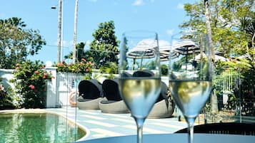 Una piscina al aire libre, sillones reclinables de piscina