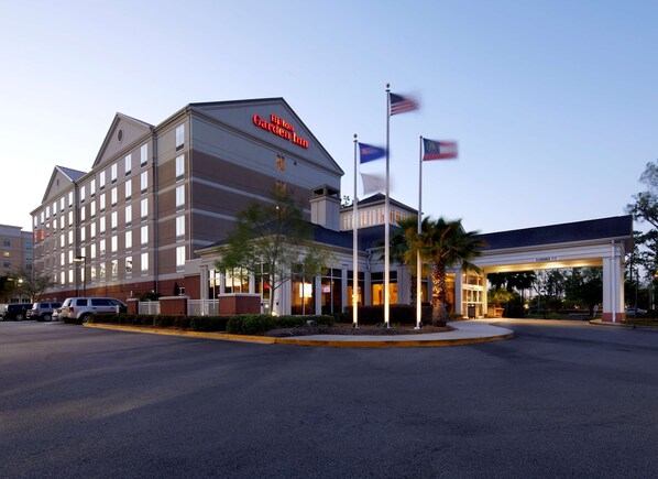 Un hôtel Hilton Garden Inn doté d’un bâtiment à plusieurs étages, d’un parking et d’une station-service.