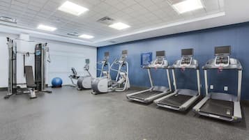 Una palestra con tapis roulant, ellittiche e attrezzature per l'allenamento con i pesi.