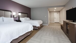 A hotel room with two beds, a TV, a desk, and a walk-in closet. - Hampton Inn & Suites Jacksonville / Orange Park (Orange Park)
