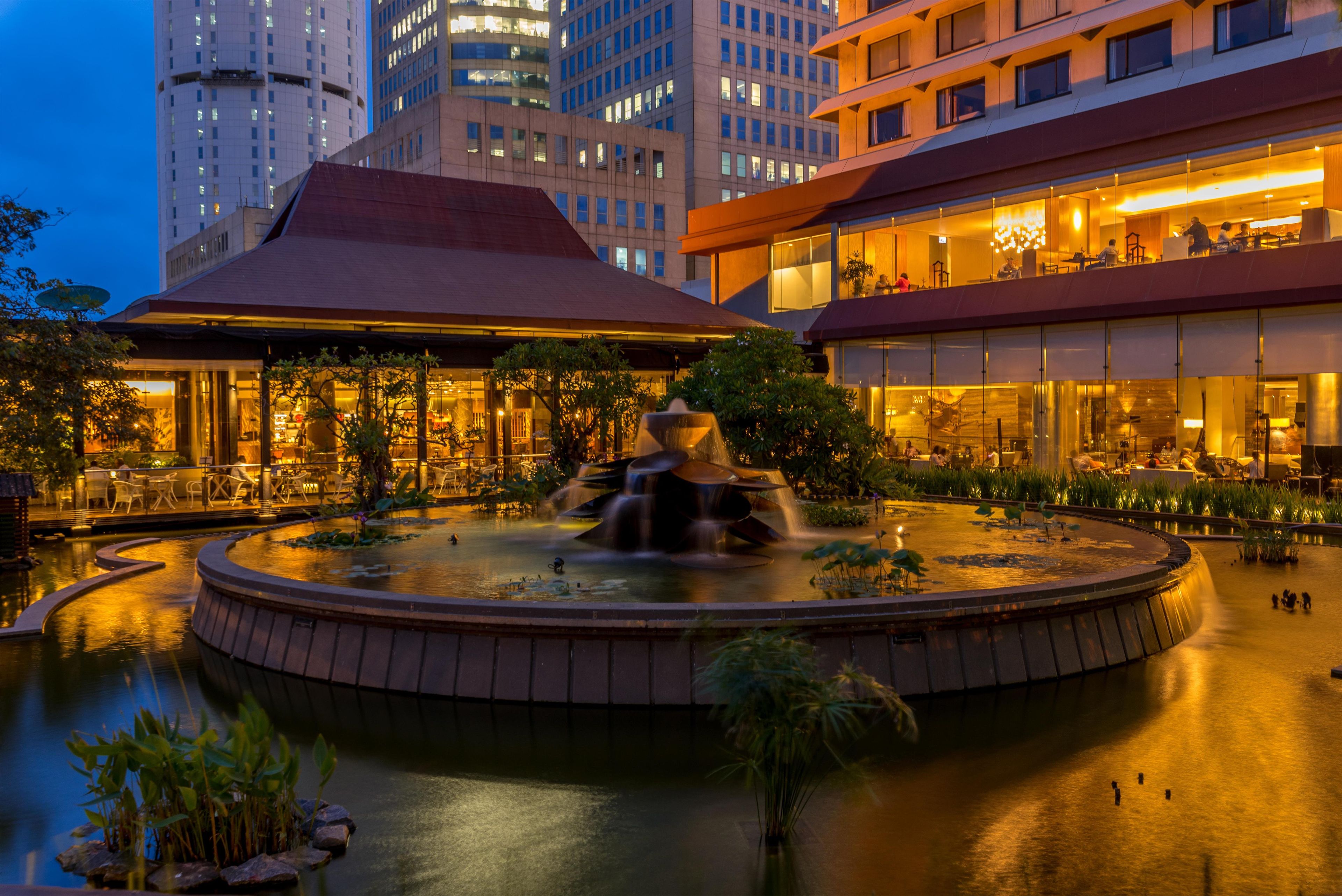 A hotel courtyard with a central water feature, surrounded by buildings.