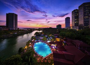 A resort with a large swimming pool, a river, and high-rise buildings in the background. - Hilton Colombo (Colombo)