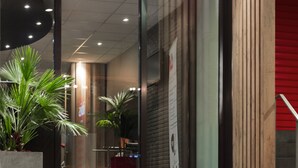 The exterior of the ibis hotel with a glass entrance, steps leading up to it, and potted plants in front. - ibis Liège Centre Opéra (Liege)