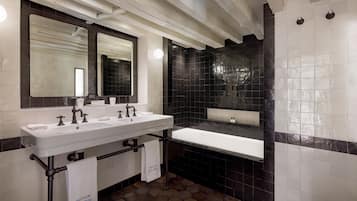 Ein modernes Badezimmer mit einem Doppelwaschbecken, großen Spiegeln und Wänden mit schwarz-weißer Fliesen.