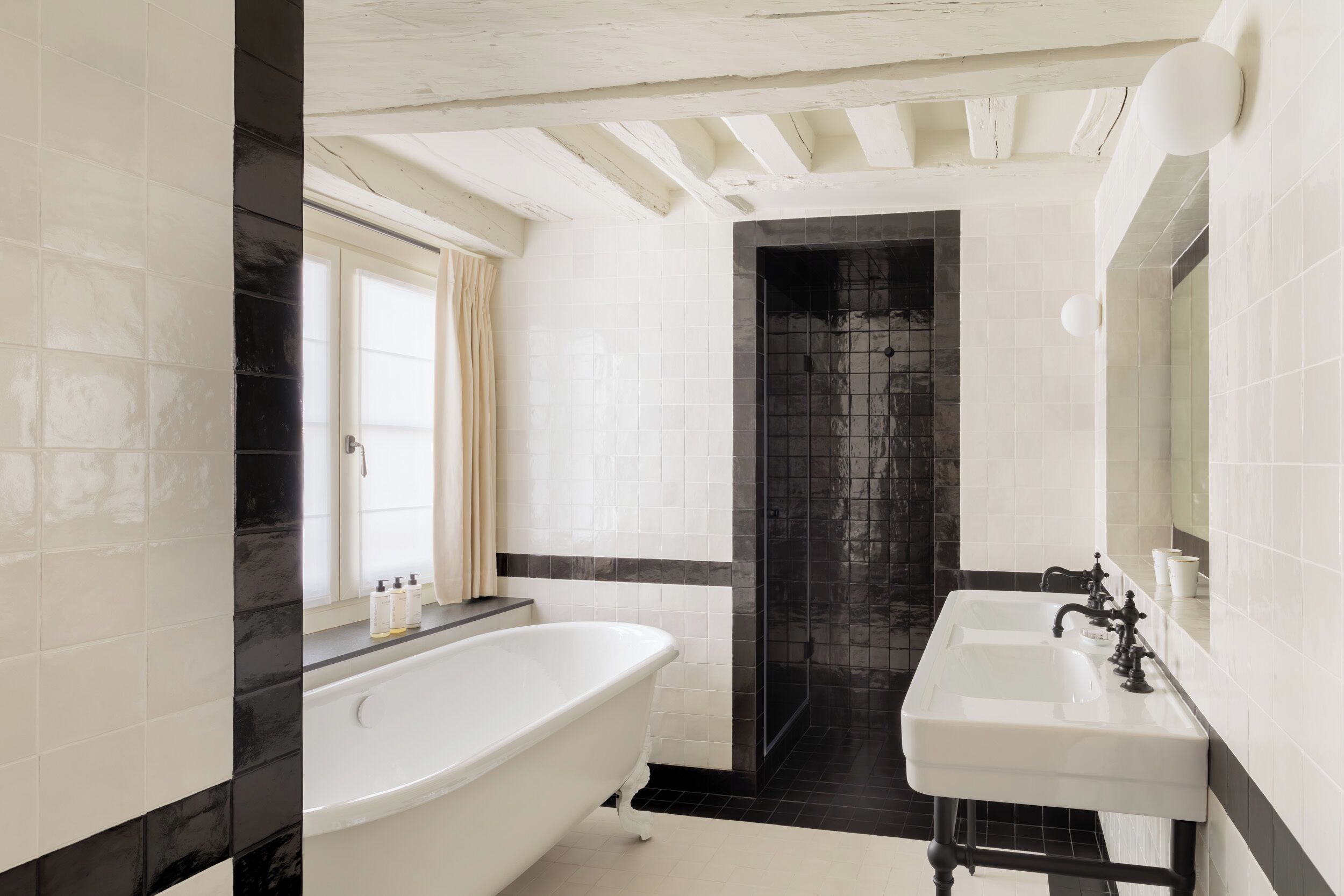 A bathroom with a freestanding bathtub, a shower area, and a sink.