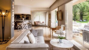 A modern living room with a sofa, a dining table, and a bar area. - La Réserve Albi - Hotel Restaurant (Albi)