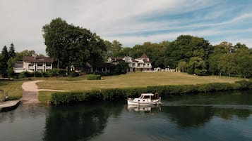 Un vaste domaine comprenant un lac, un bateau et un sentier menant à l’eau.