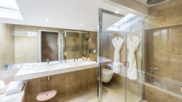 A modern bathroom with a glass-enclosed shower, a large vanity with dual sinks, and a walk-in shower.