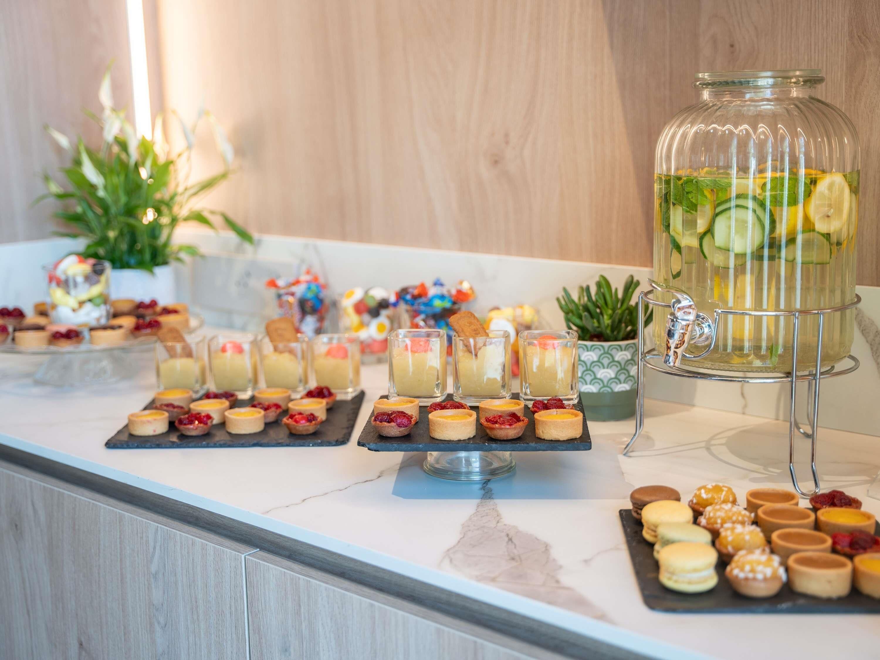 Un bufé con diversos postres y una estación de bebidas.