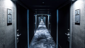 A long, narrow hallway with doors on either side, each marked with a number.