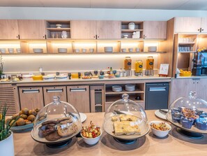 A buffet setup with various food items and beverages, including cookies, pastries, and a coffee station. - Novotel Angers Lac de Maine (Angers)