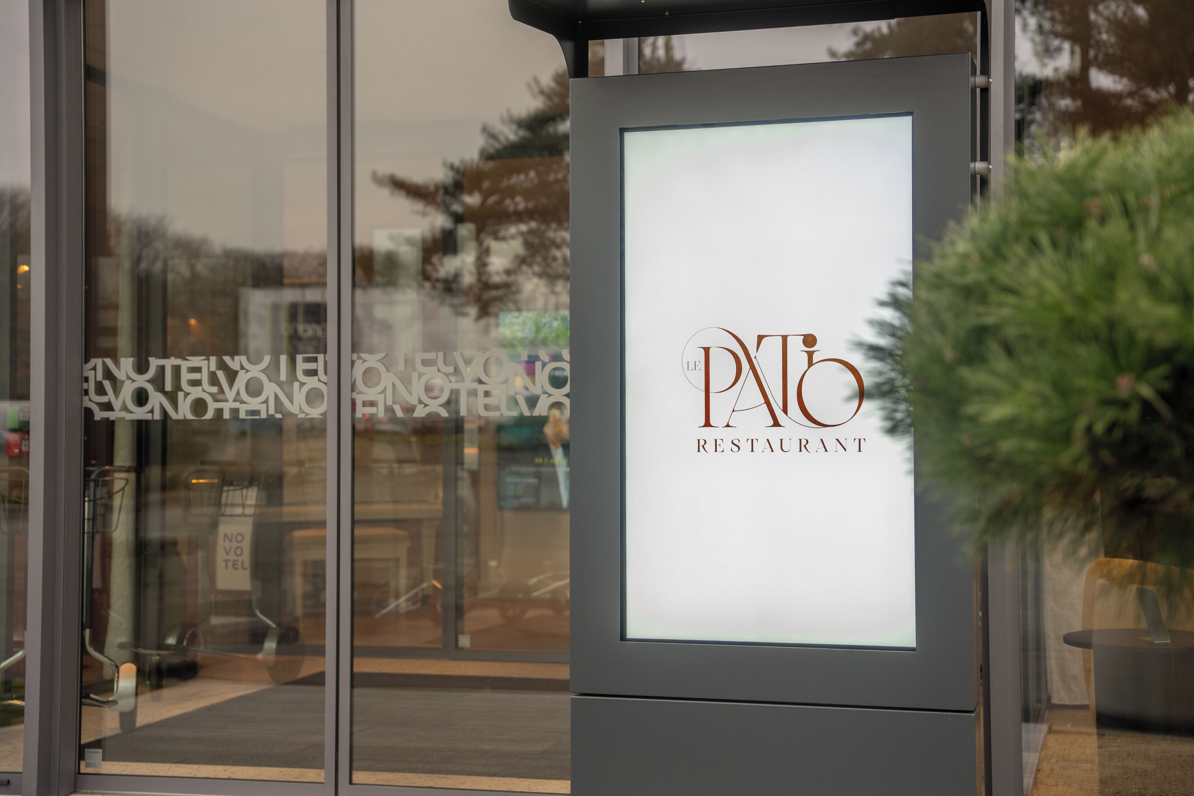 Une enseigne pour le restaurant PNT, avec une fenêtre en verre transparent en arrière-plan.
