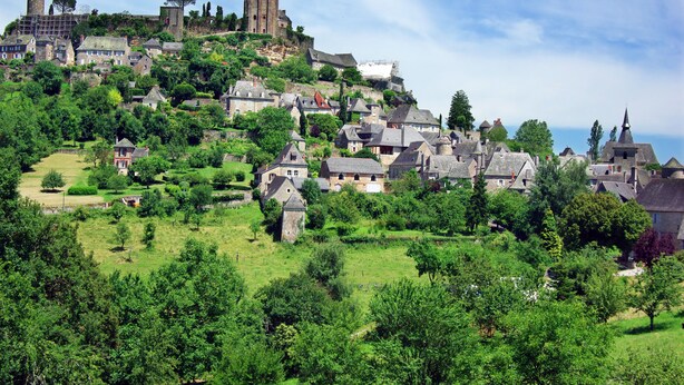 A historic town with medieval architecture, including towers and a castle on a hill. - ibis Brive Centre (Brive-la-Gaillarde)